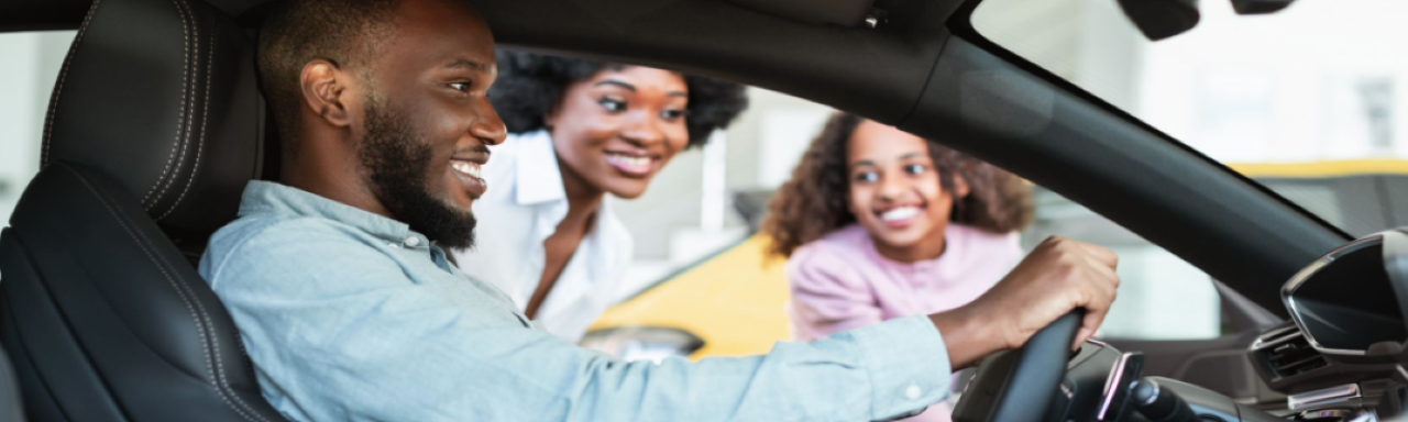 Happy customer driving away from Hall's Auto Sales dealership in a new car.