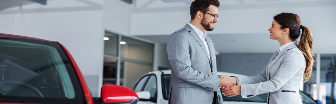 A customer shaking hands with a friendly car salesman