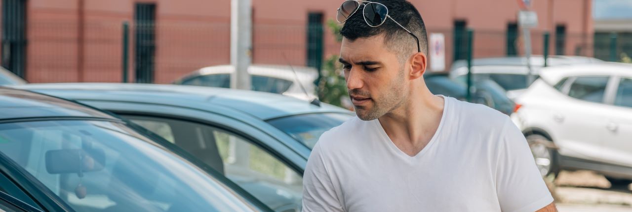 A photo of a man looking at a vehicle to portray the helpful team of Hall's Auto Sales in Mansfield, OH, helping a customer.