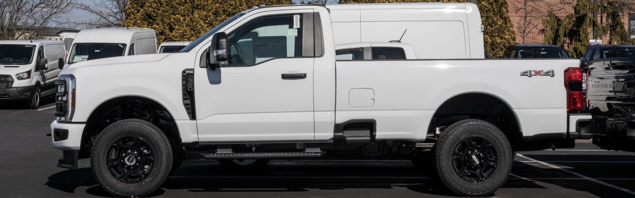 A satisfied customer driving away in a reliable pre-owned truck purchased at Hall's Auto Sales.