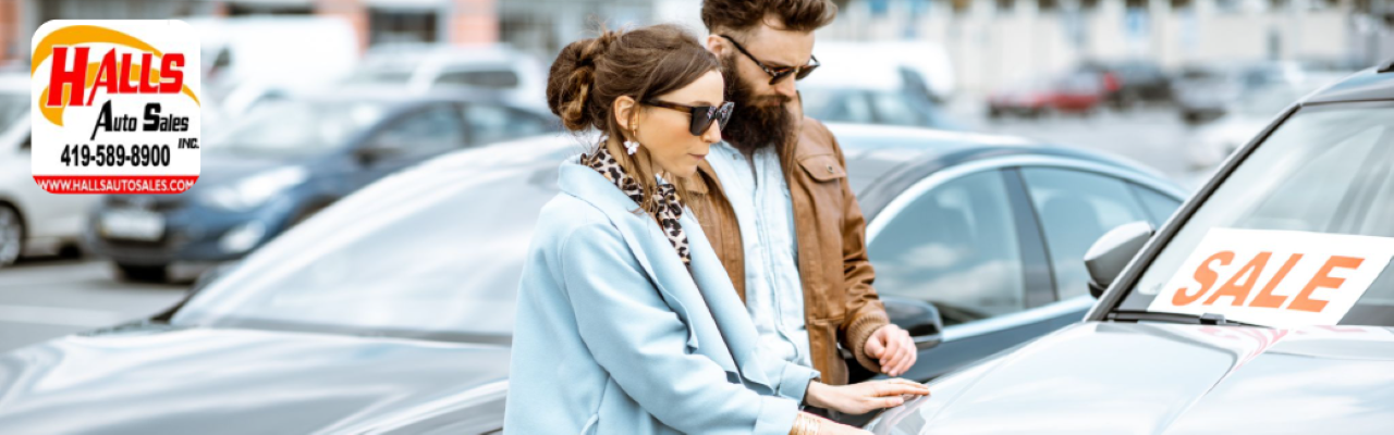 Customer reviewing vehicle options with a sales representative at Hall’s Auto in Richland County