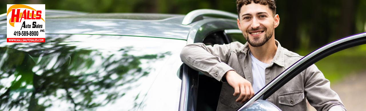 Sales associate helping customer review used car options and financing at Hall’s Auto Sales Mansfield, OH